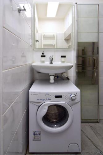 a bathroom with a washing machine and a sink at Apartman Nikola Trojanovice in Trojanovice