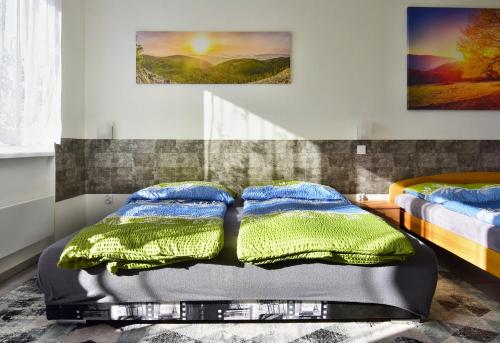 a bedroom with two beds and two paintings on the wall at Apartman Nikola Trojanovice in Trojanovice