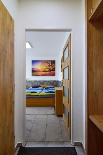 a bedroom with a bed with a painting on the wall at Apartman Nikola Trojanovice in Trojanovice