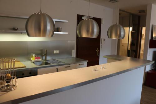 una cucina con banconi in acciaio inossidabile ed elettrodomestici in acciaio inossidabile di Center - Atelier Residence a Varsavia