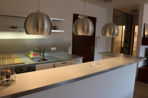 kuchnia z blatami ze stali nierdzewnej i urządzeniami ze stali nierdzewnej w obiekcie Center - Atelier Residence w Warszawie