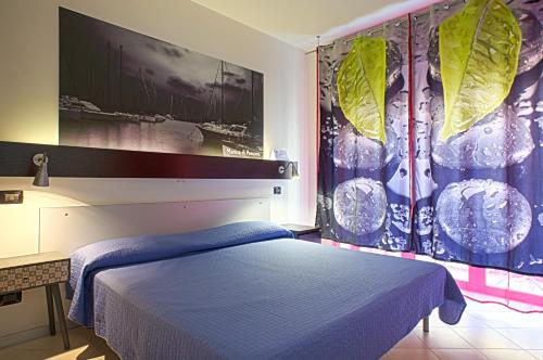 um quarto com uma cama azul e uma parede com cartazes em Bella Pescara Bb - Abruzzo, Italy em Pescara