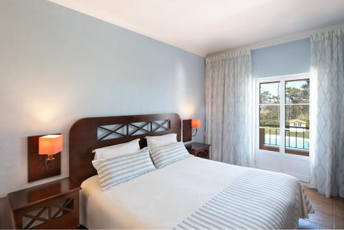 a bedroom with a large bed and a window at Hotel Rural Monte da Leziria in Santo André