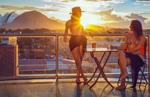 a man and a woman sitting at a table on a balcony at Hotel Marcoantonio - Moyobamba in Moyobamba