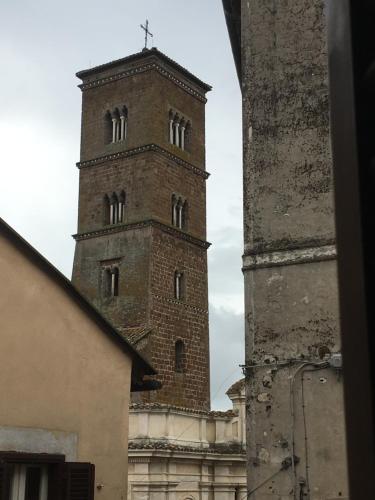una torre alta con una cruz en la parte superior de un edificio en Localetto bed & dinner, en Sutri