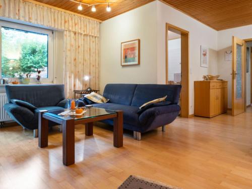 a living room with a blue couch and a table at Holiday home in Kyllburg Eifel near the forest in Kyllburg