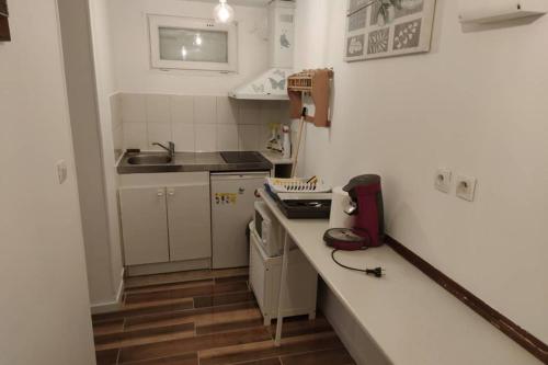 une petite cuisine avec un comptoir et un évier dans l'établissement Bel Appart entre Paris et Dysney équipé (Ref:KL0), à Montfermeil