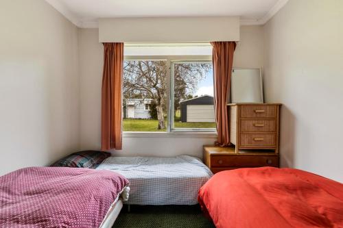 - une chambre avec 2 lits et une fenêtre dans l'établissement Cedar Cottage - Tauranga Taupo Holiday Home, à Kuratau