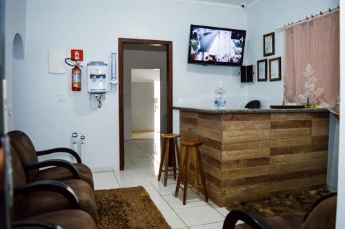 a kitchen with a bar with a tv on the wall at Hostel Prime in Rio Verde