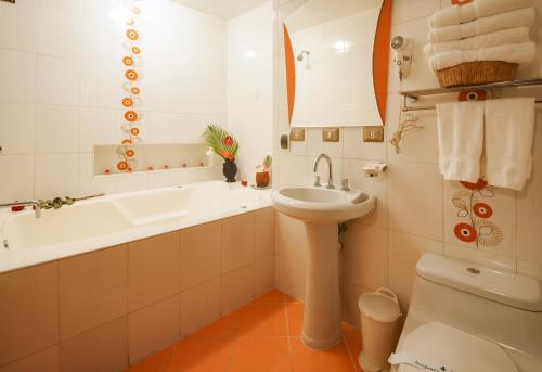 a bathroom with a tub and a sink and a toilet at Hotel Marcoantonio - Moyobamba in Moyobamba