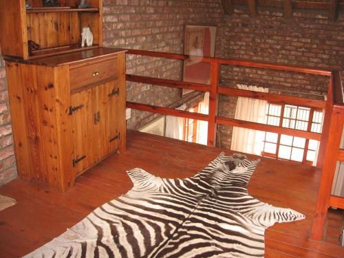 a zebra laying on the floor of a room at Intaba Lodge in Kirkwood