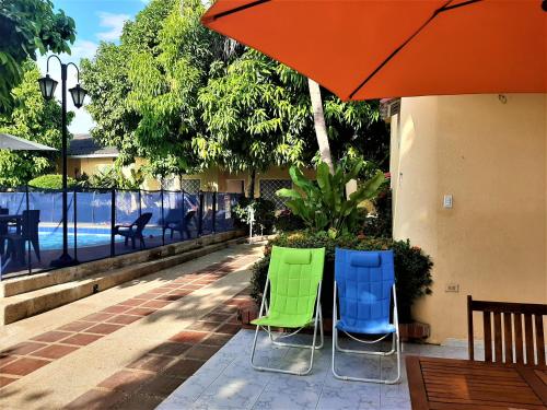 two chairs and an umbrella on a patio at Condominio El Portal Casa 1 in Carmen de Apicalá
