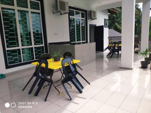 a yellow table and chairs in front of a building at Captain's Cabin Resort - Naval Heritage (Swimming Pool) in Kota Bharu