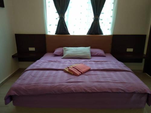 a purple bed with two pillows and a window at Captain's Cabin Resort - Naval Heritage (Swimming Pool) in Kota Bharu