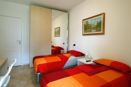 a hotel room with two beds and a mirror at Belcolle, il bello della tranquillità in Chiavenna