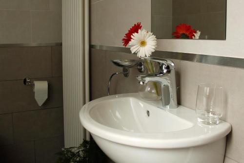 a white sink in a bathroom with a glass at Belcolle, il bello della tranquillità in Chiavenna