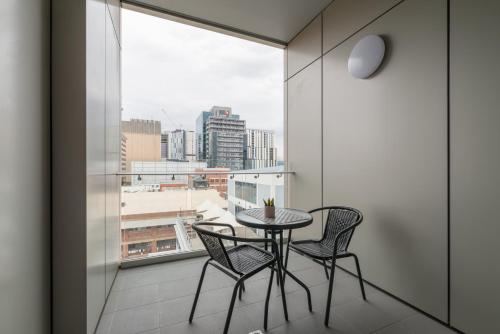 a table and chairs on a balcony with a view at Tasha's Apartments on Morphett in Adelaide