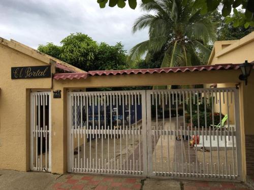 a white gate in front of a building at Condominio El Portal Casa 1 in Carmen de Apicalá