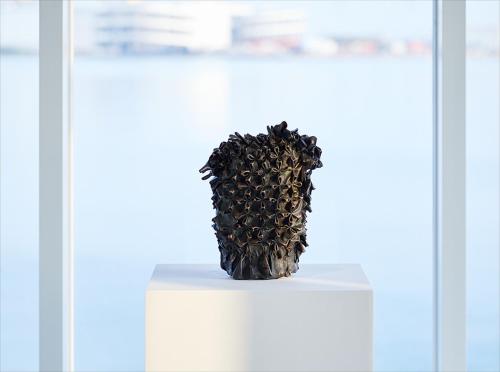 a black vase sitting on top of a white table at HOTEL ANTEROOM NAHA in Naha