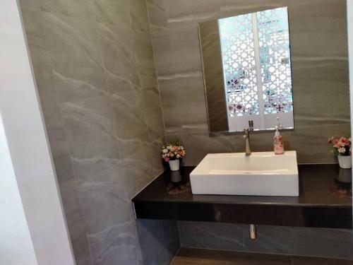 a bathroom with a white sink and a mirror at Feelathome in Chiang Rai