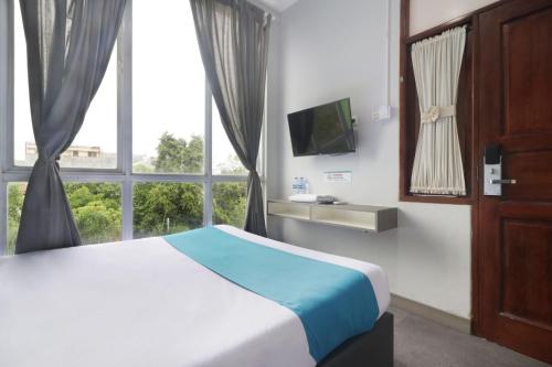 ein Schlafzimmer mit einem Bett und einem großen Fenster in der Unterkunft Sambina in Jakarta