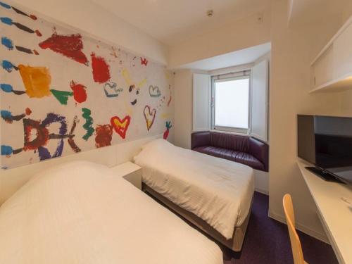 a room with two beds and a desk and a tv at Hotel Art Stay Naha Kokusai-Dori in Naha
