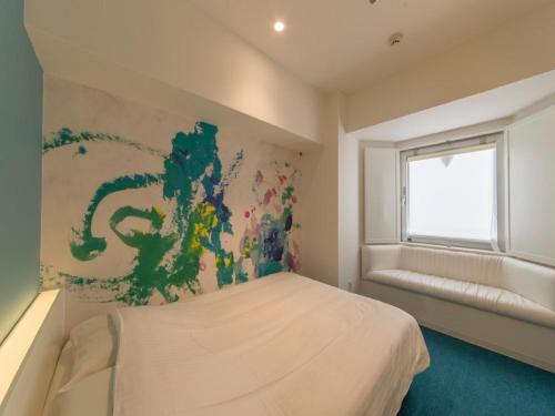 a bedroom with a bed with a painting on the wall at Hotel Art Stay Naha Kokusai-Dori in Naha