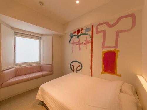 a bedroom with a bed and a window at Hotel Art Stay Naha Kokusai-Dori in Naha