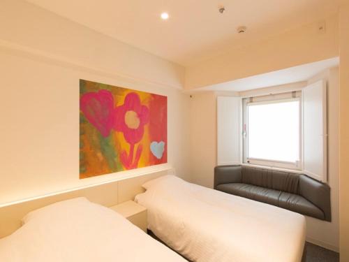 a bedroom with two beds and a painting on the wall at Hotel Art Stay Naha Kokusai-Dori in Naha