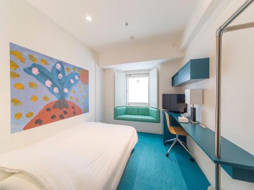 a bedroom with a bed and a desk with a computer at Hotel Art Stay Naha Kokusai-Dori in Naha