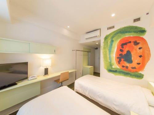 a bedroom with two beds and a painting on the wall at Hotel Art Stay Naha Kokusai-Dori in Naha