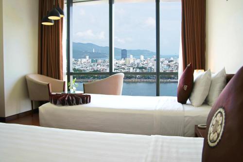 Postel nebo postele na pokoji v ubytování Da Nang Han River Hotel