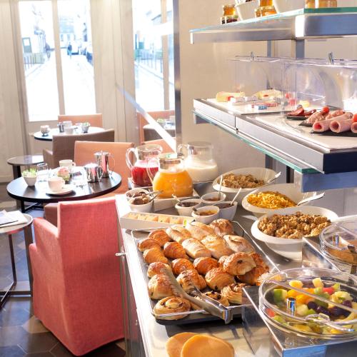 um buffet com muitos tipos diferentes de comida em Hotel Saint Dominique em Paris