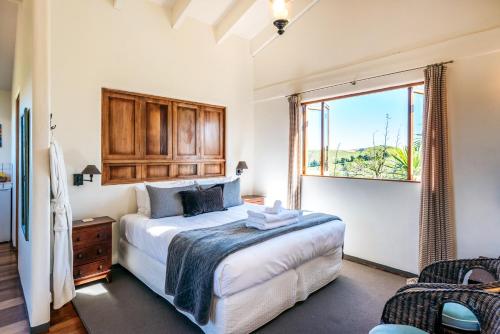 The Loft at Cypress Ridge Estate في Onetangi: غرفة نوم بسرير كبير ونافذة