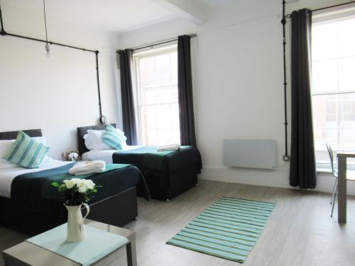 a room with two beds and a table with a couch at Queen Street Apartments in Wolverhampton