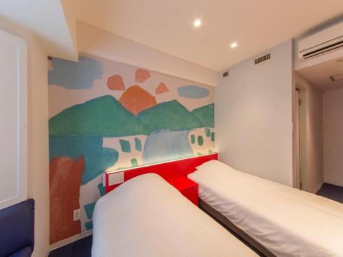 a bedroom with two beds and a painting on the wall at Hotel Art Stay Naha Kokusai-Dori in Naha