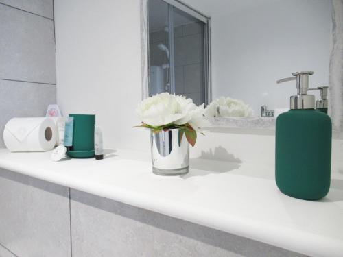 a bathroom with a green soap dispenser on a sink at Queen Street Apartments in Wolverhampton