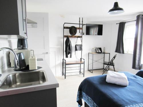 a kitchen with a sink and a bed in a room at Queen Street Apartments in Wolverhampton