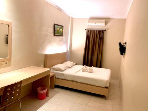 a small room with a bed and a sink at Sky View Hotel Managed by OS in Batam Center