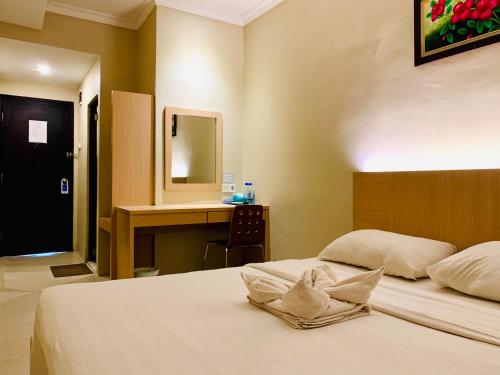 a hotel room with two beds and a desk at Sky View Hotel Managed by OS in Batam Center