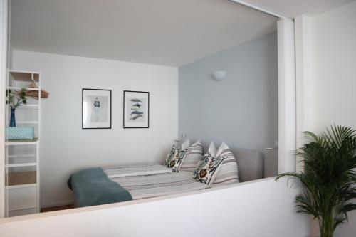 グラーツにあるCentral Premium Apartment FREE Parking & Self Check-inのソファと椅子付きの部屋の鏡