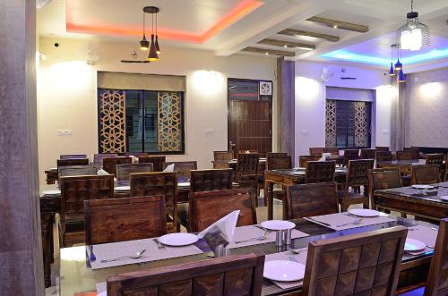 Krishna Kunj في أودايبور: غرفة طعام مع طاولات وكراسي خشبية