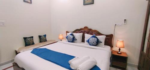 Krishna Kunj في أودايبور: غرفة نوم بسرير كبير ومخدات زرقاء وبيضاء