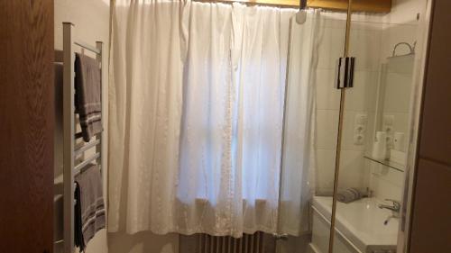 シェッファウ・アム・ヴィルデン・カイザーにあるLandhaus Hoschekのバスルーム(白いシャワーカーテン、シンク付)