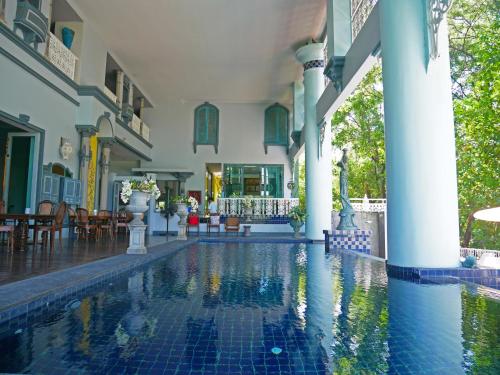 a swimming pool in a building with a house at At Pingnakorn Huaykaew in Chiang Mai