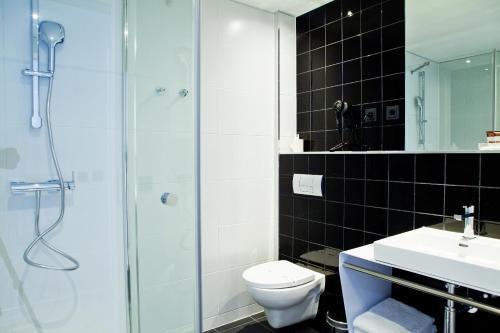 a bathroom with a shower and a toilet and a sink at Catalonia Berlin Mitte in Berlin