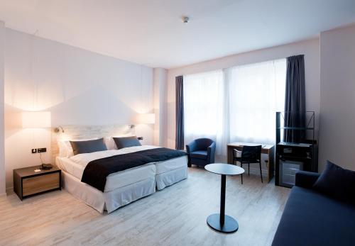 a hotel room with a bed and a desk and a chair at Catalonia Berlin Mitte in Berlin