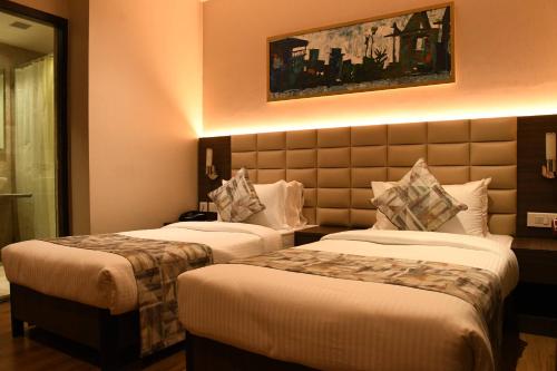 ein Hotelzimmer mit zwei Betten in einem Zimmer in der Unterkunft LYNQ AERO in Kalkutta