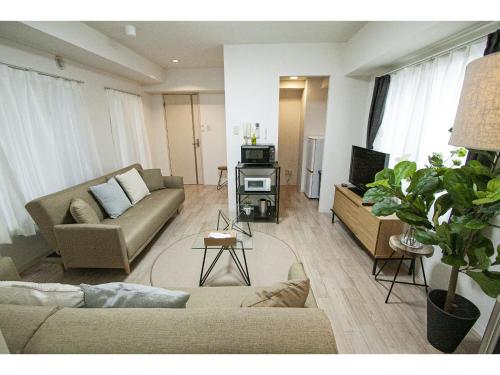 een woonkamer met een bank en een tv bij SAPPORO HILLS in Sapporo