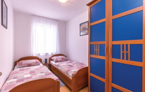 a room with two beds and a blue door at Apartman Mikulić Makarska in Makarska